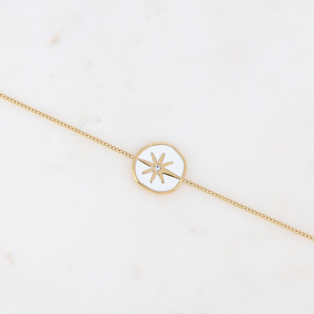 Bracelet chaîne doré composé d'une médaille étoile émaillé blanc serti d'un strass blanc