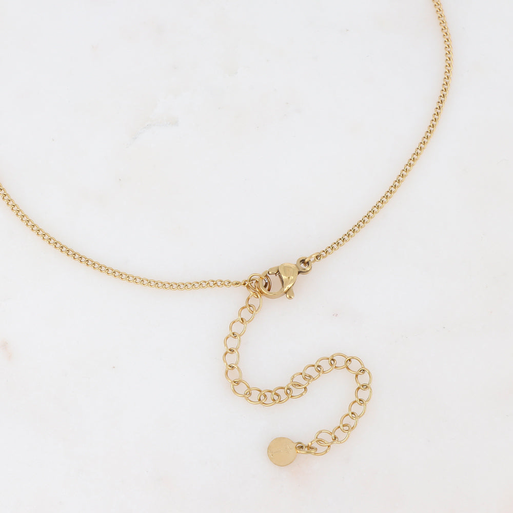 Collier sur chaîne doré composé d'un pendentif étoile émaillé blanc serti d'un strass blanc